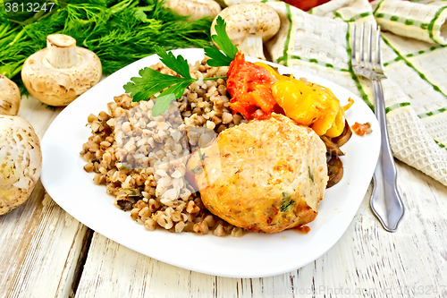 Image of Cutlets of turkey with buckwheat in plate on board