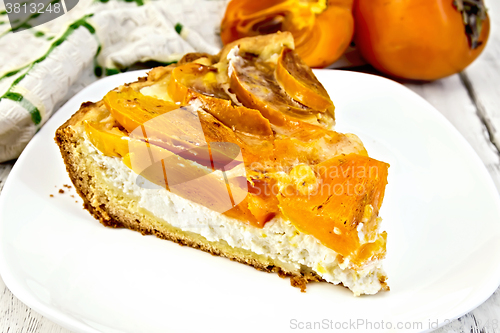 Image of Pie with curd and persimmons in plate on board