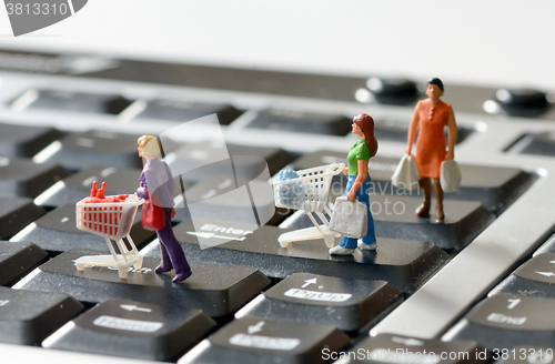 Image of Miniature shoppers  with shopping cart 