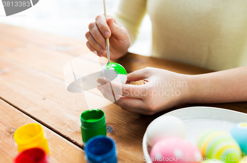 Image of close up of woman hands coloring easter eggs