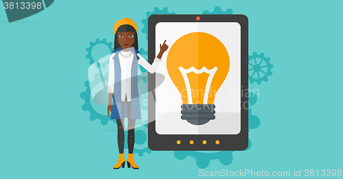 Image of Woman pointing at tablet computer with light bulb on screen.