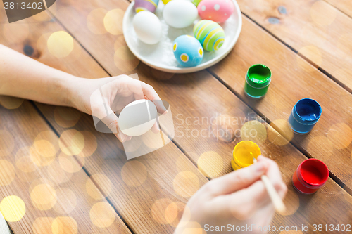 Image of close up of woman hands coloring easter eggs