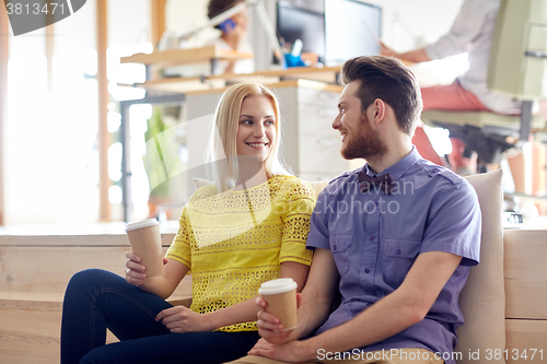 Image of happy man and woman drinking coffee in office