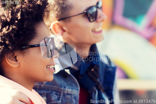 Image of happy teenage friends in shades outdoors