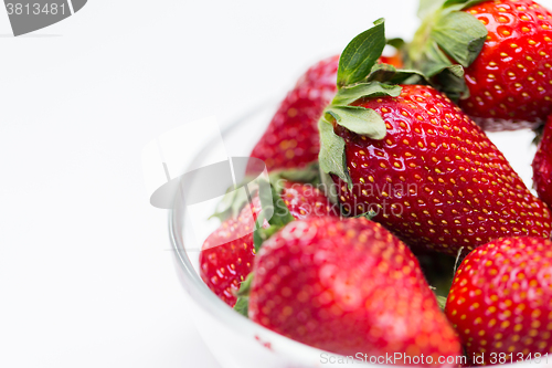 Image of close up of ripe red strawberries over white