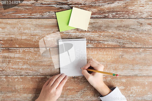 Image of close up of hands with notebook and stickers