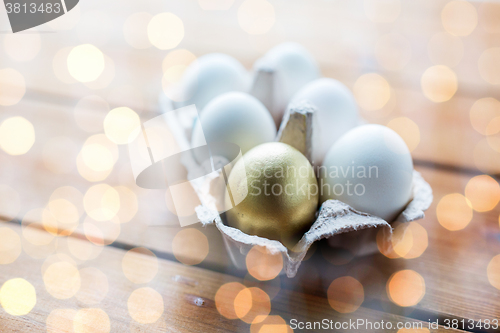 Image of close up of white and gold eggs in egg box