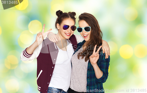 Image of smiling teenage girls in sunglasses showing peace