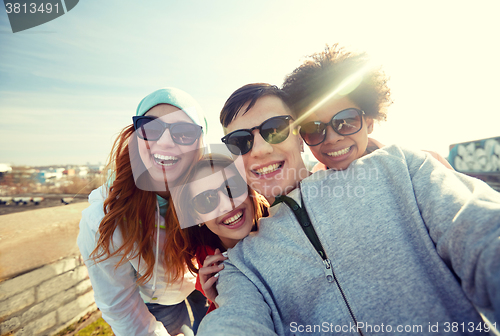 Image of group of happy friends taking selfie on street