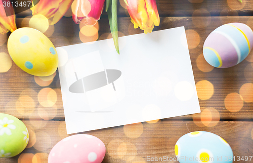 Image of close up of easter eggs, flowers and white paper