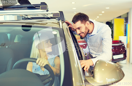 Image of happy couple buying car in auto show or salon