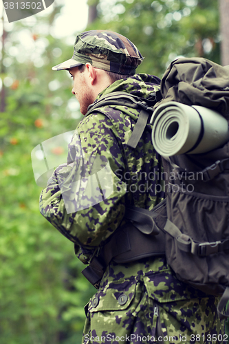 Image of young soldier with backpack in forest