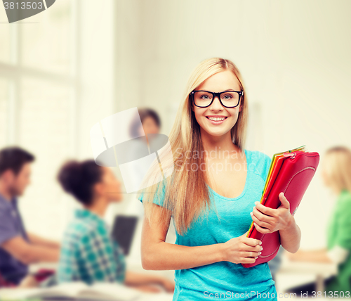 Image of smiling student with folders in eyeglasses