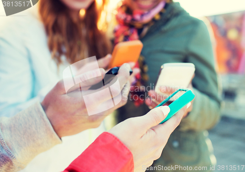 Image of close up of friends with smartphones outdoors