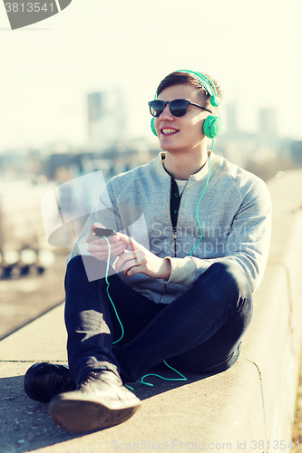 Image of happy young man in headphones with smartphone