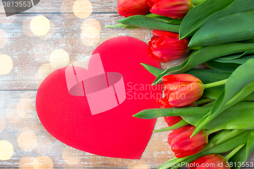 Image of close up of red tulips and paper heart shape card