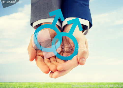 Image of close up of happy male gay couple with love symbol