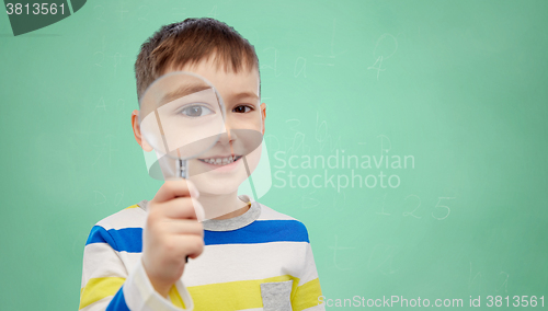 Image of happy little boy looking through magnifying glass