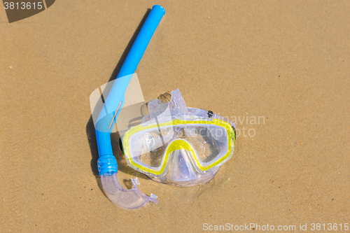 Image of The swimming mask and snorkel to breathe under water, lie on the wet sand at the sea coast