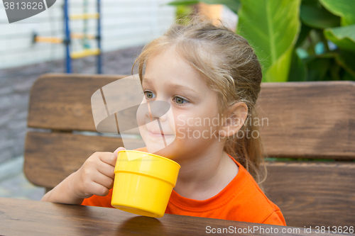 Image of Four-year girl smiling holding a glass of juice