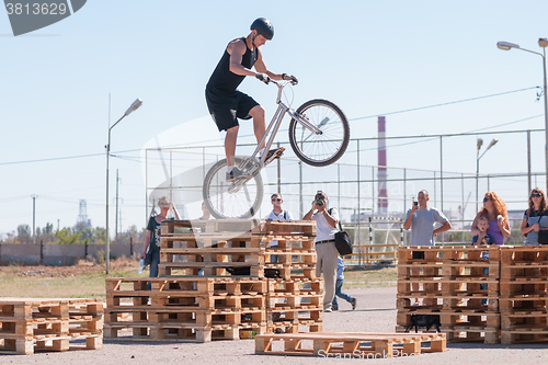 Image of Cyclist tracer jumping on a wooden pallet in front of audience