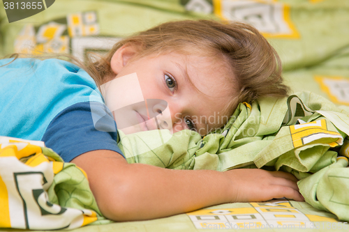 Image of Girl lying on the bed and looking to the right