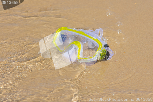 Image of The swimming mask lying on the sand at the waters edge