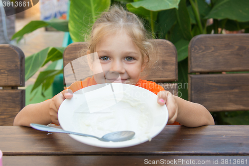 Image of Five-year girl showing empty plate to eat
