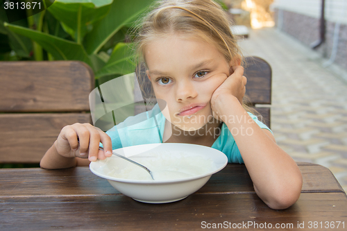 Image of Six year old girl does not want to eat porridge for breakfast