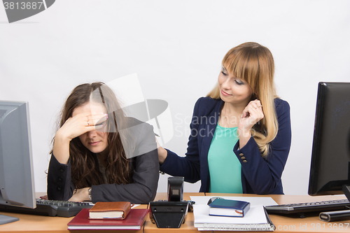 Image of The girl in the office soothes the dismissed colleague