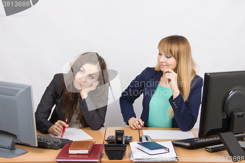 Image of The situation in the office - one girl is very upset, others are pretty straightens things on your desktop