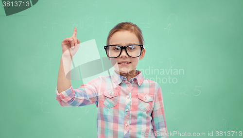 Image of girl in glasses pointing finger up over green