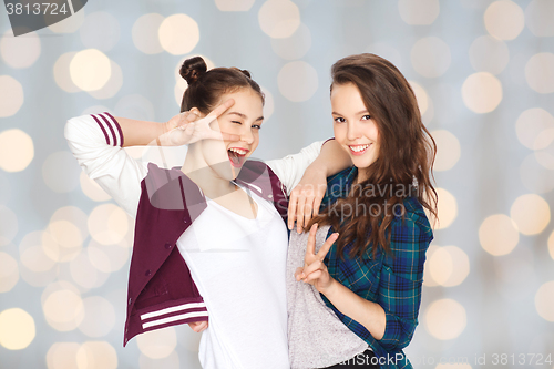 Image of happy pretty teenage girls showing peace hand sign