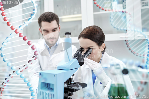 Image of scientists with microscope making test in lab