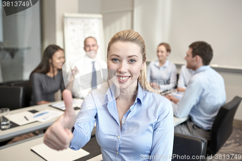 Image of group of smiling businesspeople meeting in office