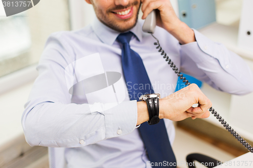 Image of businessman dialing number and calling on phone