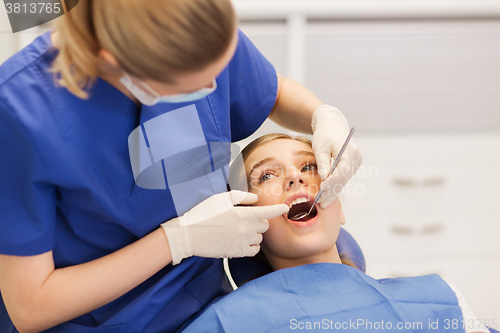 Image of female dentist checking patient girl teeth