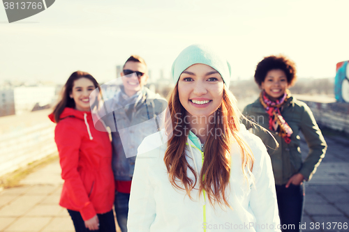 Image of group of happy teenage friends on city street