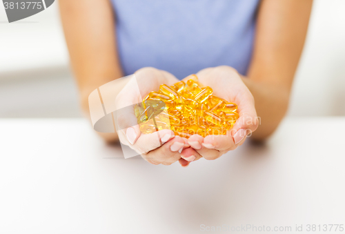 Image of close up of woman hands holding pills or capsules