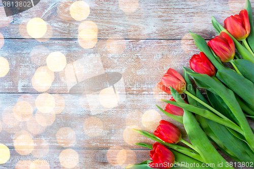 Image of close up of red tulips on wooden background