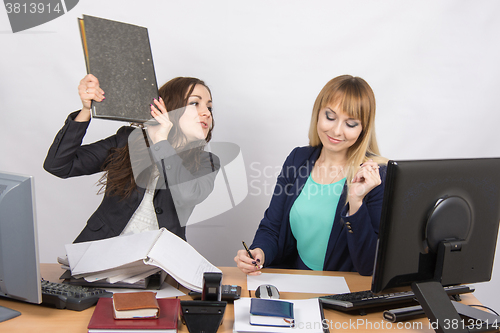 Image of The girl in the office threatens to hit another folder employee