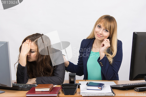 Image of An employee of the office soothes his distressed colleague
