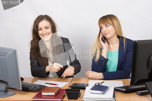 Image of The situation in the office - an employee of a colleague who laughs on the phone