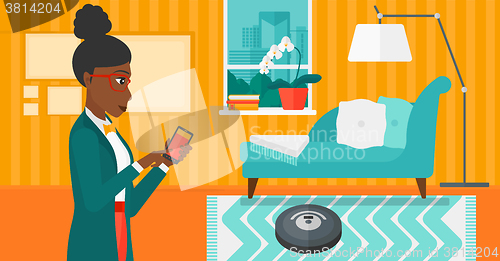 Image of Woman with robot vacuum cleaner.