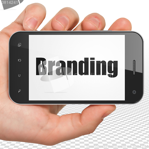 Image of Marketing concept: Hand Holding Smartphone with Branding on display