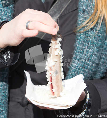 Image of Dutch woman is eating typical raw herring