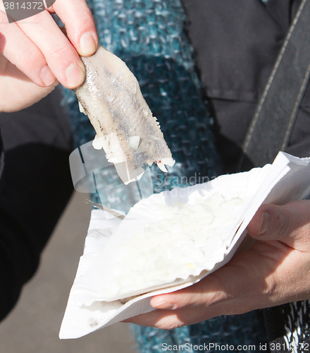 Image of Dutch woman is eating typical raw herring