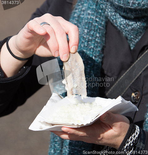 Image of Dutch woman is eating typical raw herring