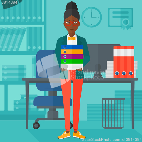 Image of Woman holding pile of folders.