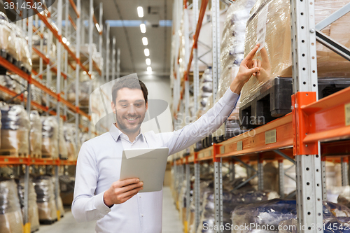 Image of happy businessman with tablet pc at warehouse